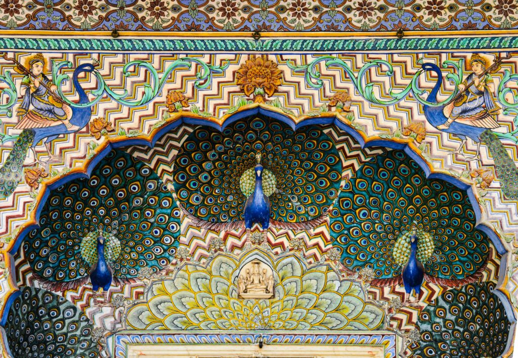 Beautifully ornamented peacock mosaic on a historic Jaipur palace wall showcasing rich colors and artistry.