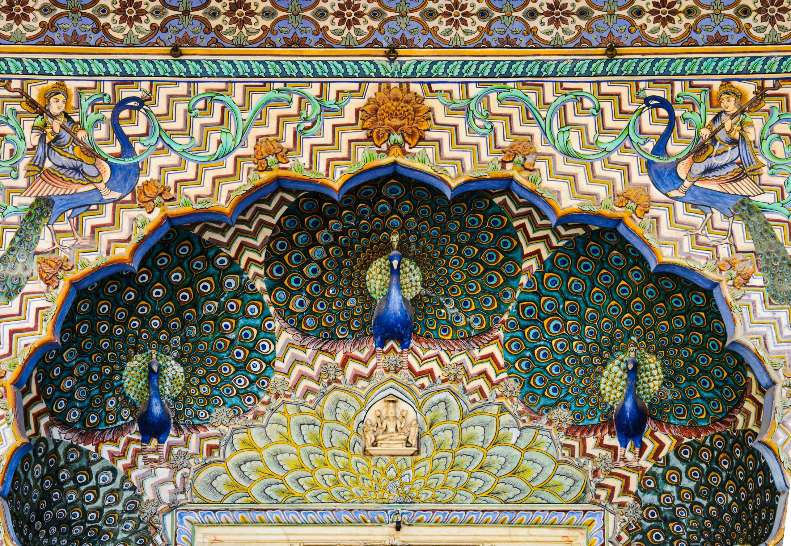 Beautifully ornamented peacock mosaic on a historic Jaipur palace wall showcasing rich colors and artistry.