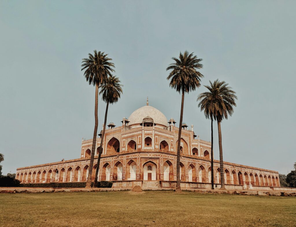 Captured view of Humayun's Tomb in New Delhi, framed by palm trees, a UNESCO World Heritage Site.